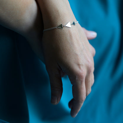 Silver bracelet with three triangles on model's wrist