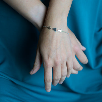 Silver bracelet with three triangles on model's wrist